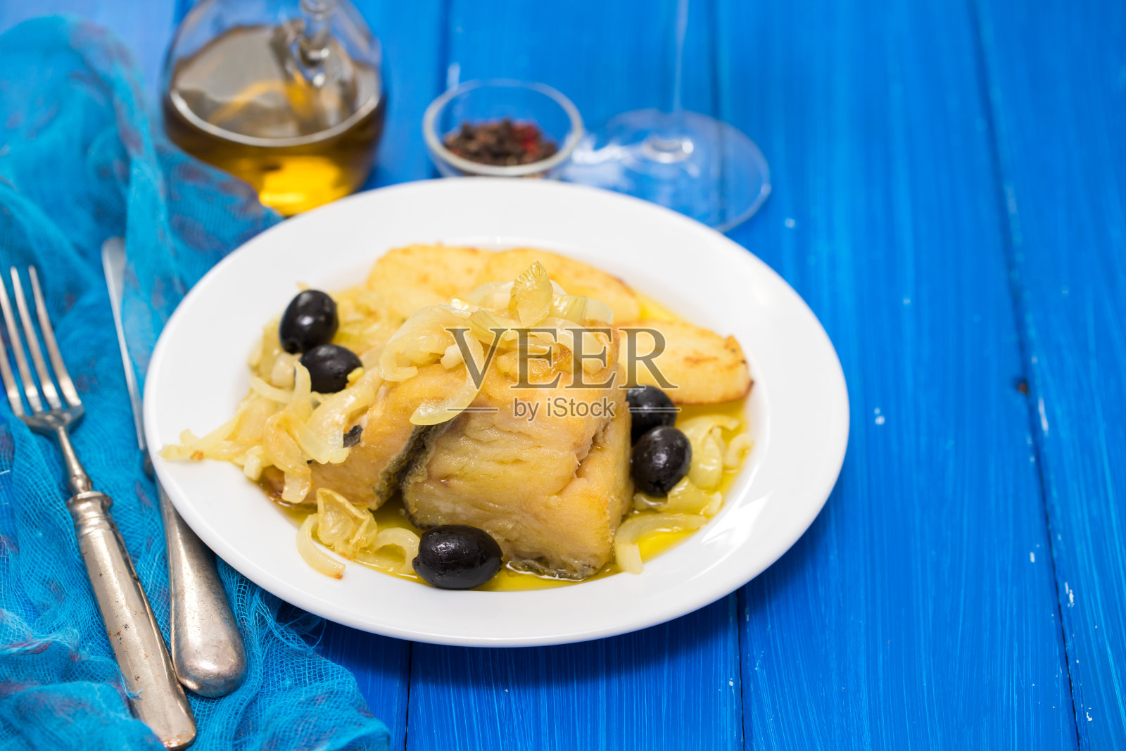 煎鳕鱼，洋葱和土豆放在白色盘子里照片摄影图片