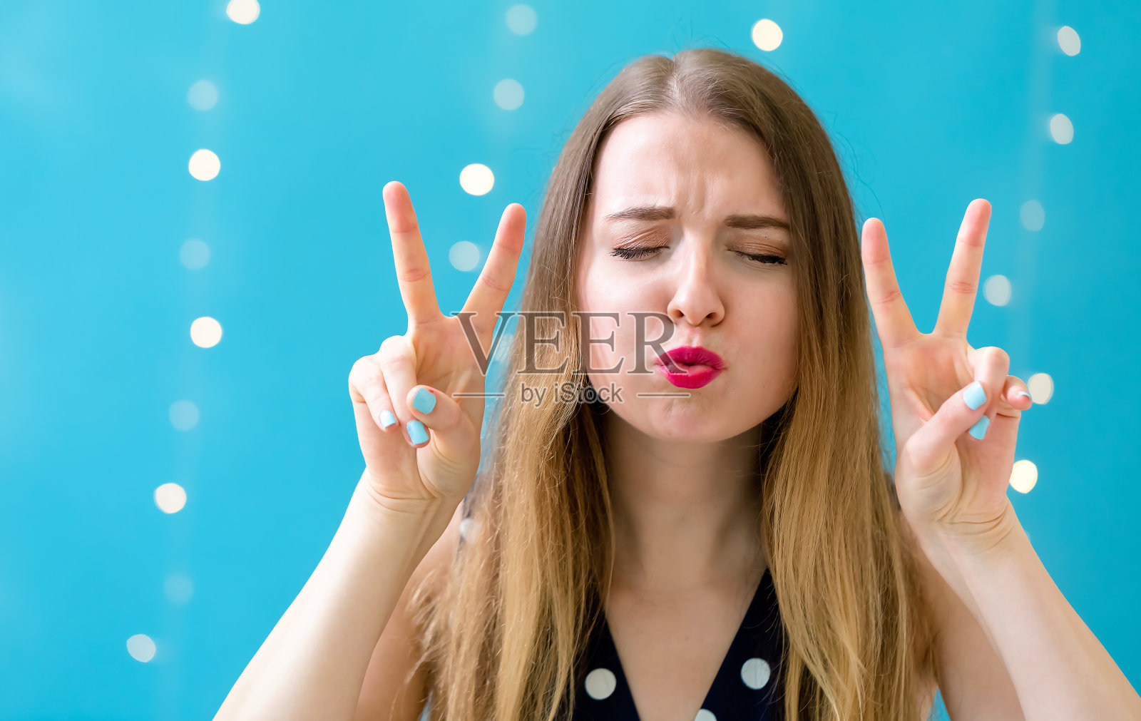 年轻的女人做了个和平的手势照片摄影图片