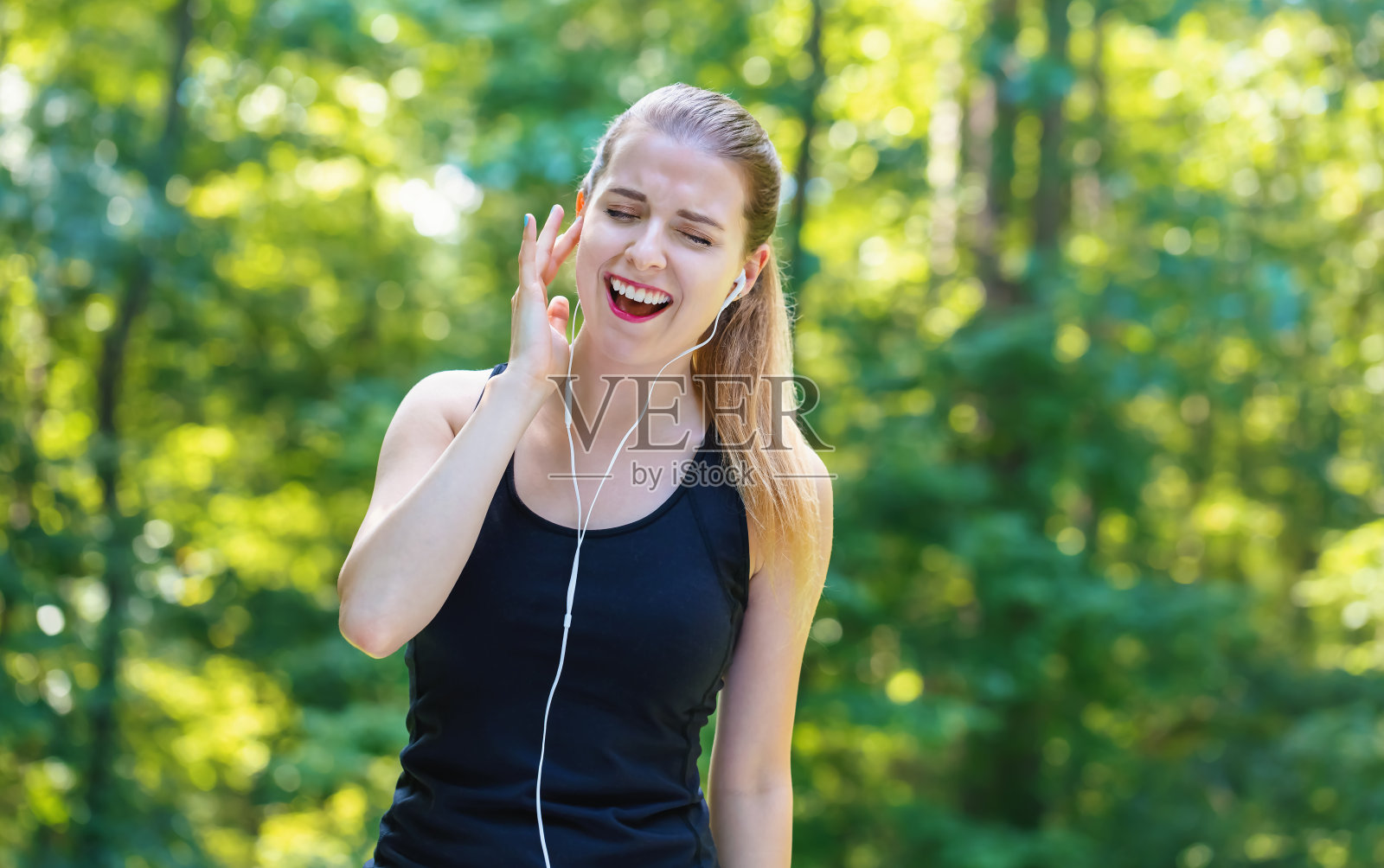 运动的年轻女子戴着耳机照片摄影图片
