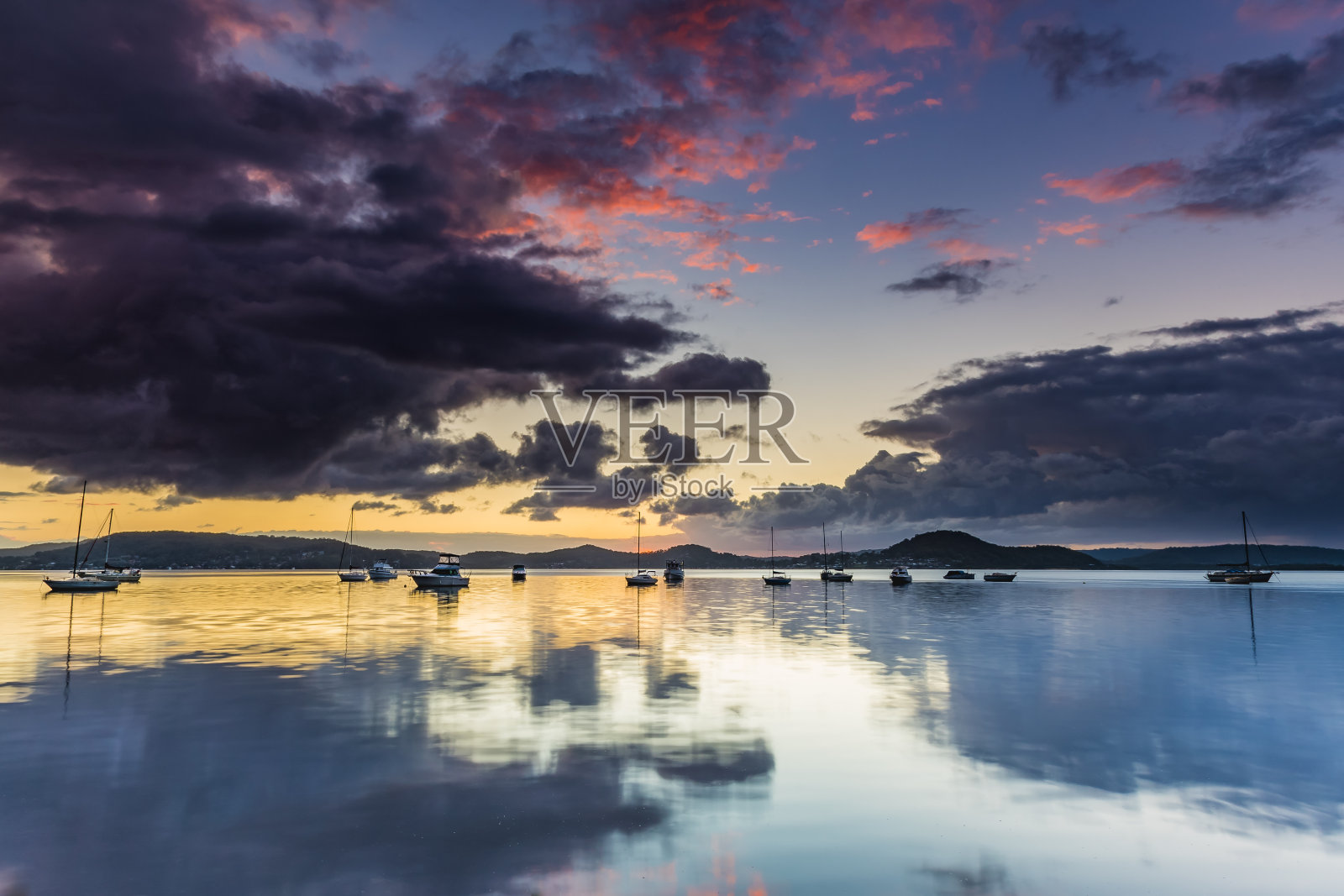 与船在海湾上的阴天晨光照片摄影图片
