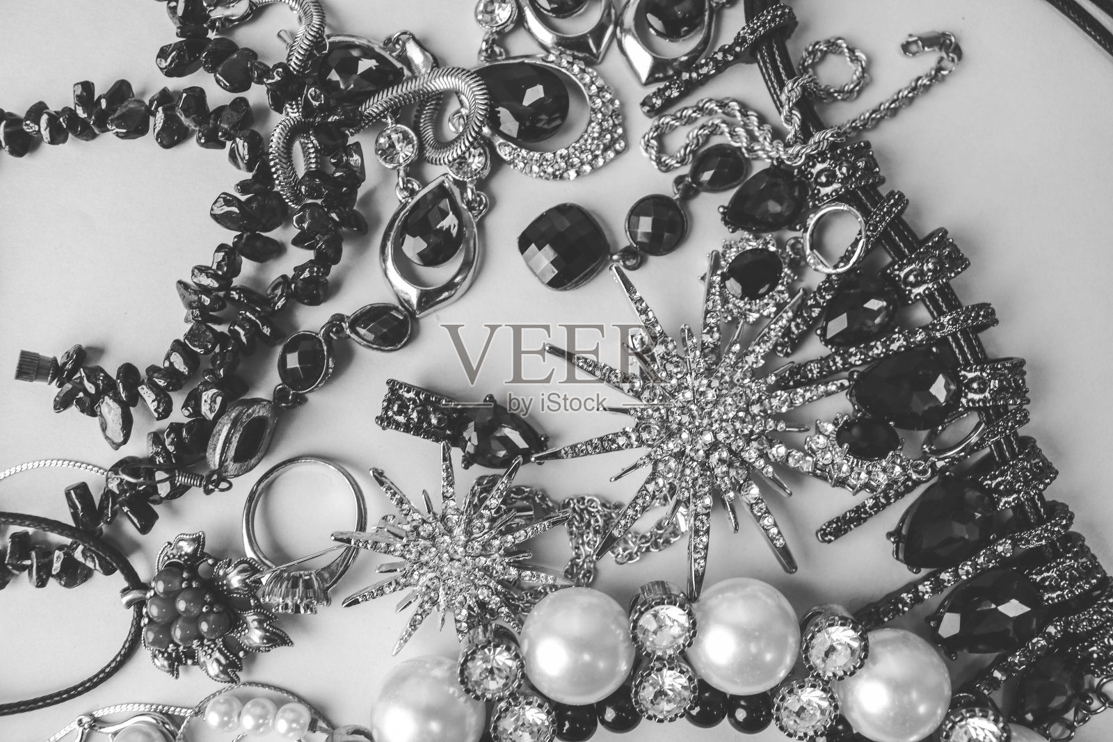 美丽的珍贵闪亮的珠宝时尚迷人的珠宝套装，项链，耳环，戒指，链，胸针与珍珠和钻石在黑色和白色的背景。平放，俯视图，复制的地方照片摄影图片