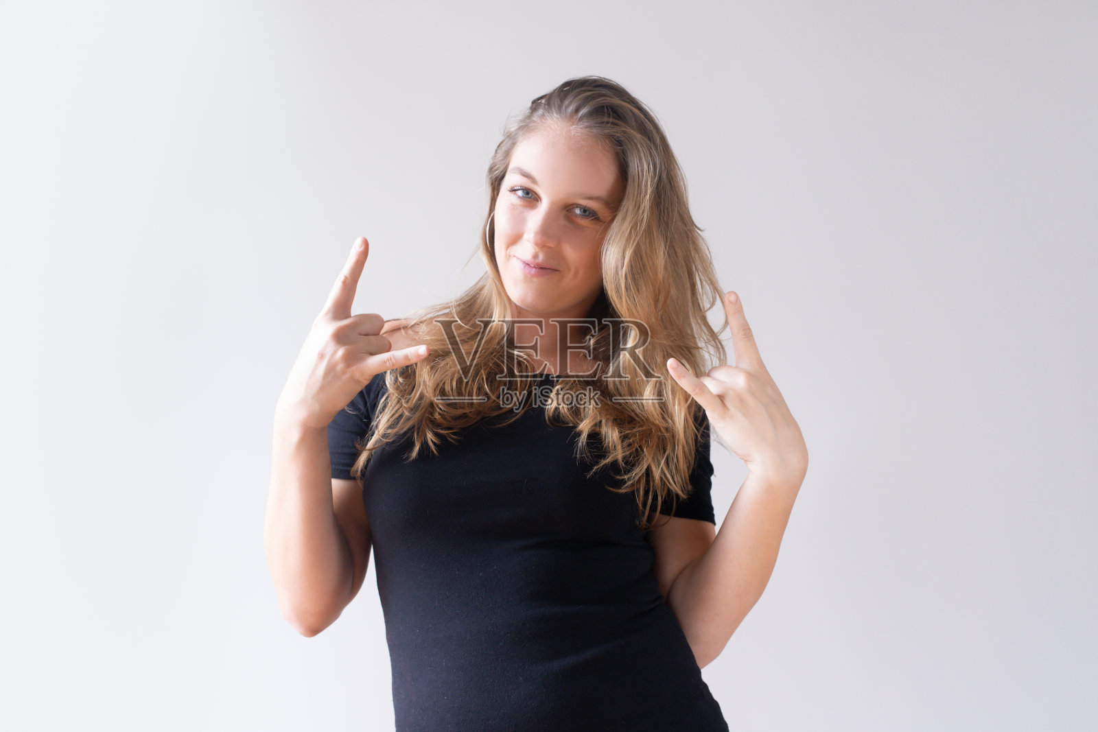 满意的漂亮的白人女孩做摇滚音乐手势照片摄影图片