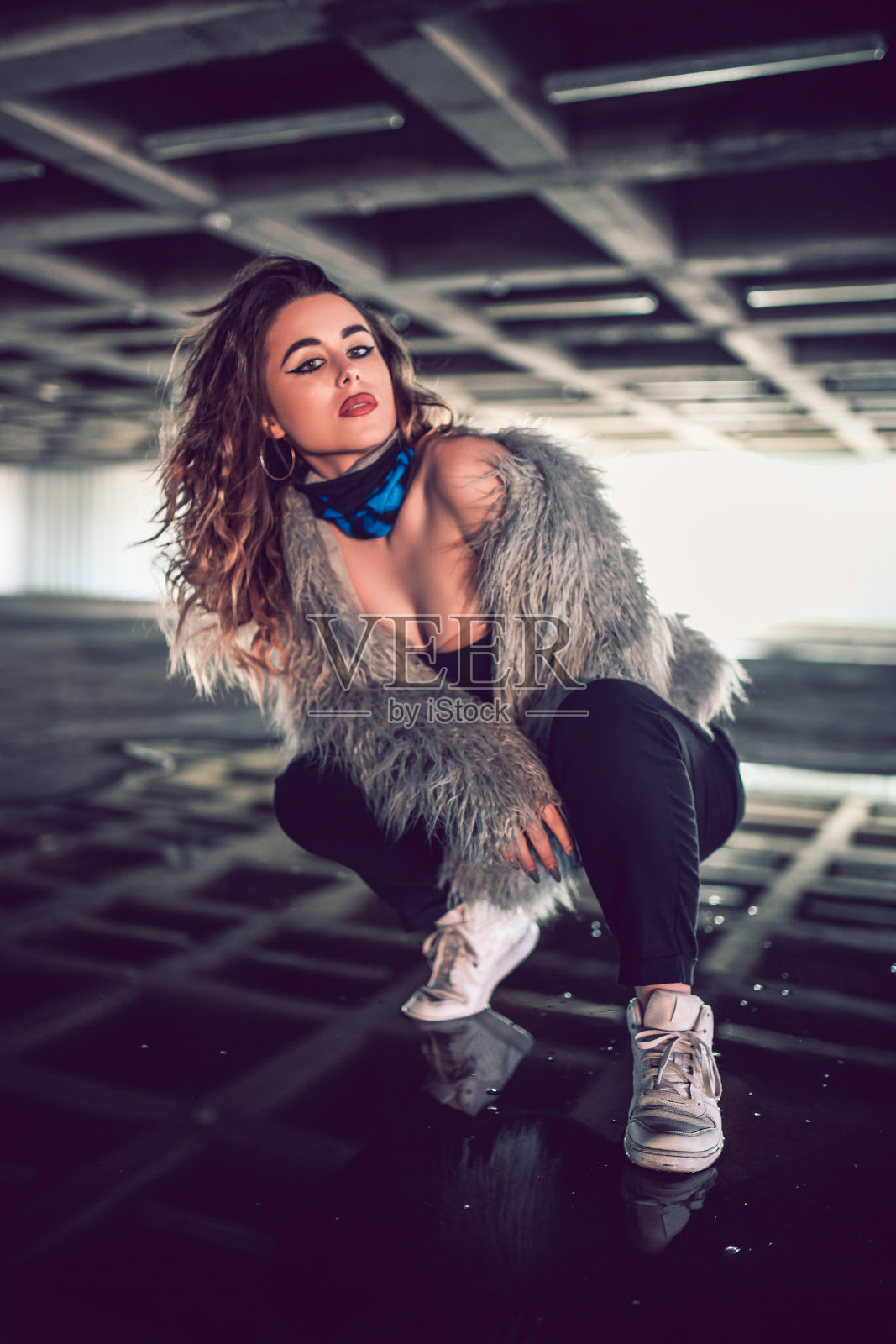 都市时尚女性在一个空的停车场以跪姿摆姿势照片摄影图片