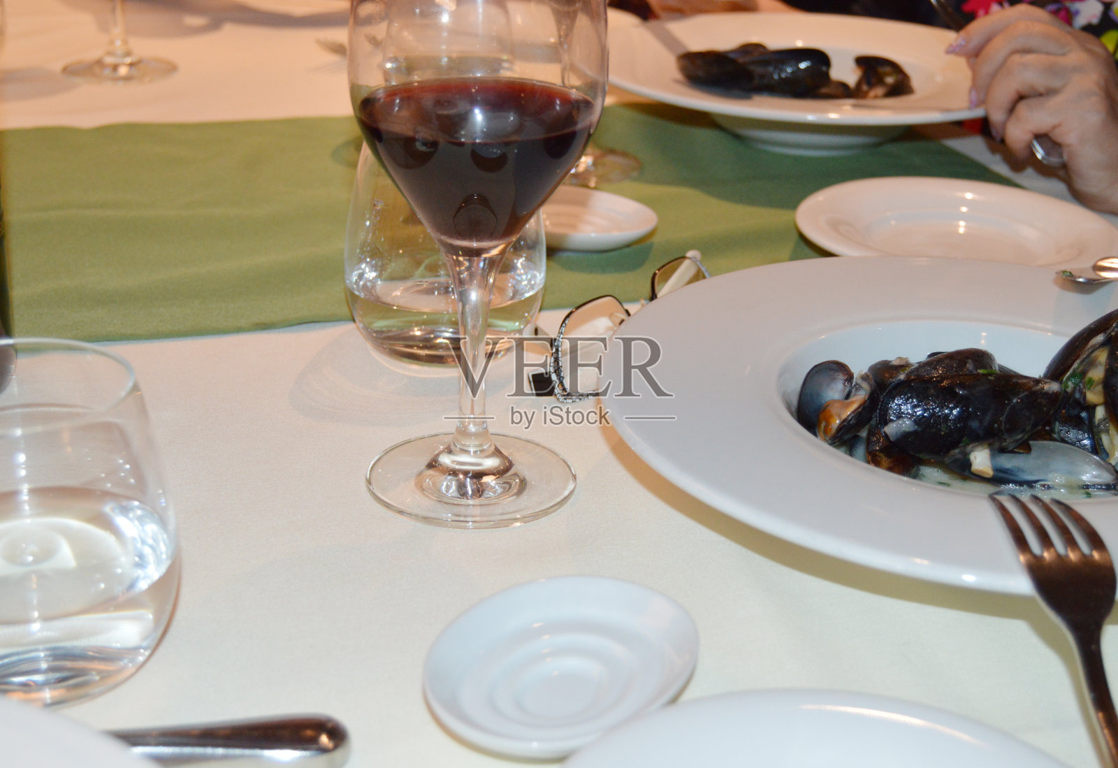 晚餐在传统的意大利餐厅，海鲜，贻贝盘和一杯红酒照片摄影图片
