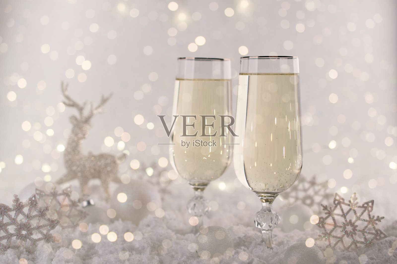 庆祝新年和圣诞节。两个香槟杯和节日装饰。美丽闪亮的地方设置为圣诞节。闪光背景，冬季。照片摄影图片
