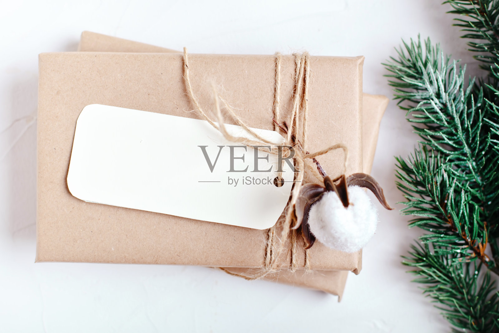 圣诞快乐，恭贺新禧。模型与明信片和树枝的圣诞树在白色的背景。背景与复制空间。前视图。圣诞节的背景。垂直的。照片摄影图片