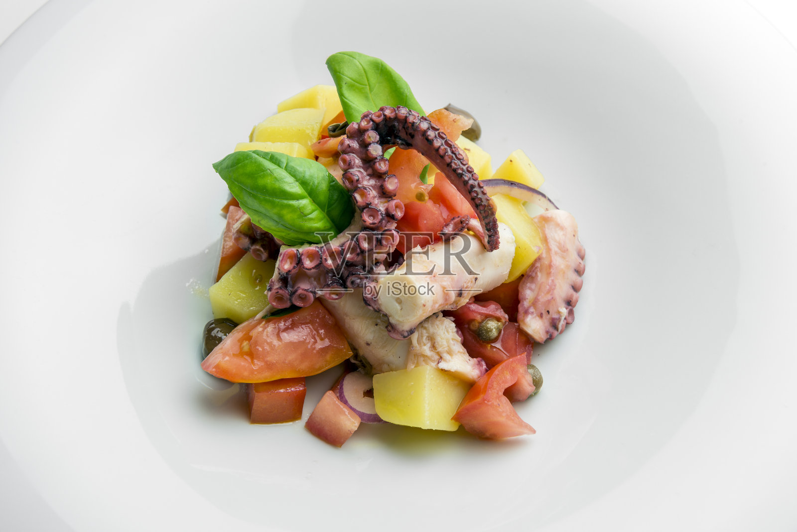 配以章鱼、土豆、酸豆、西红柿和罗勒的沙拉照片摄影图片