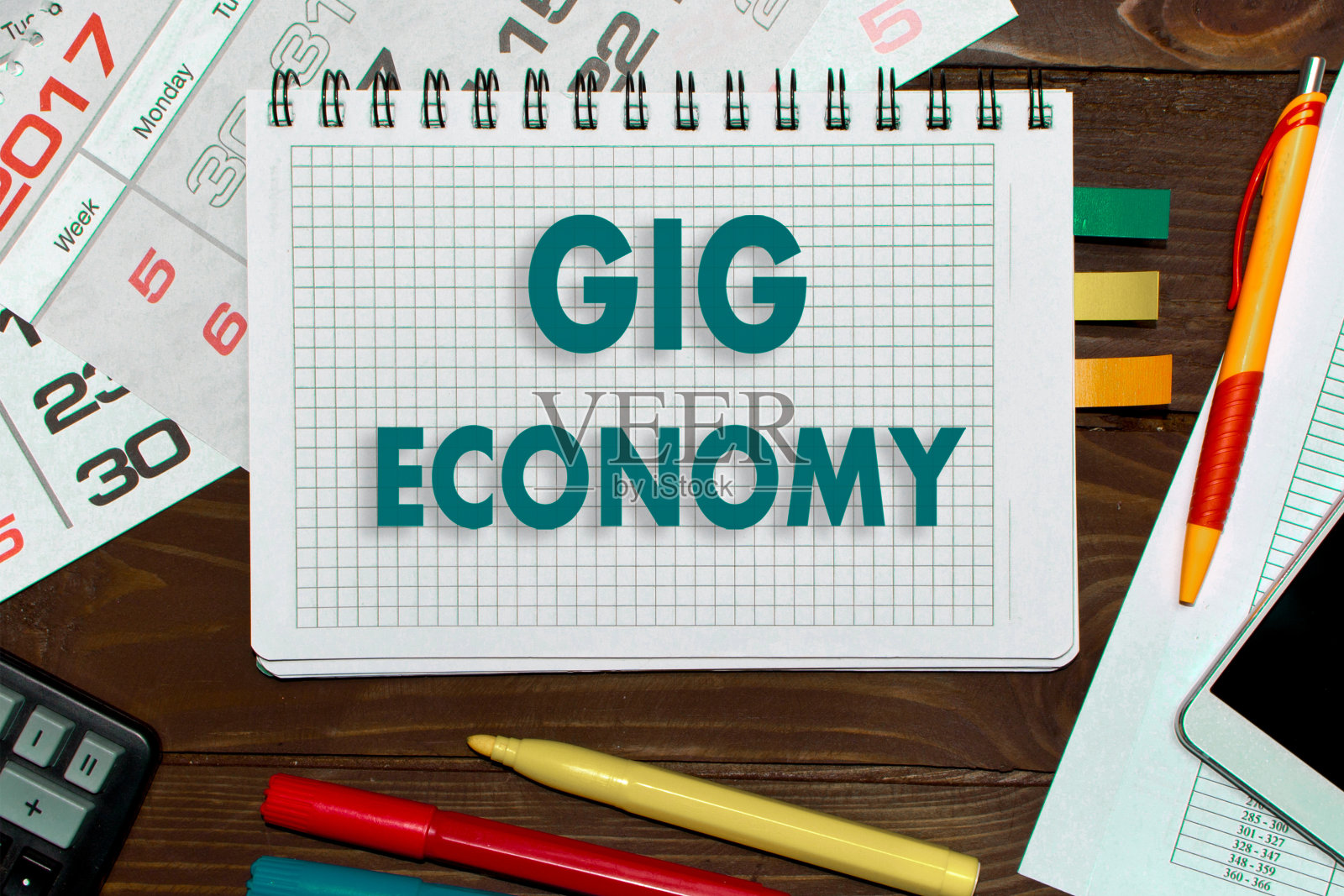 带着笔记的笔记本和零工经济工具放在办公桌上。照片摄影图片