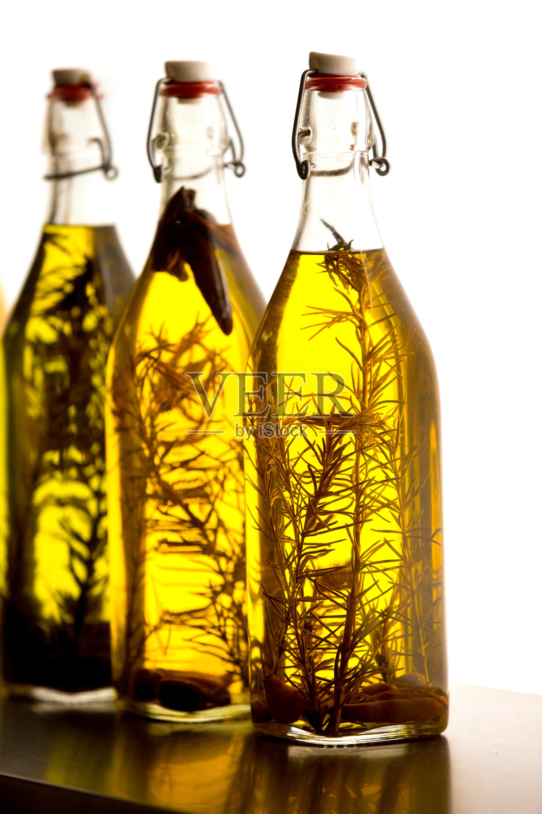 装有油和迷迭香的瓶子照片摄影图片