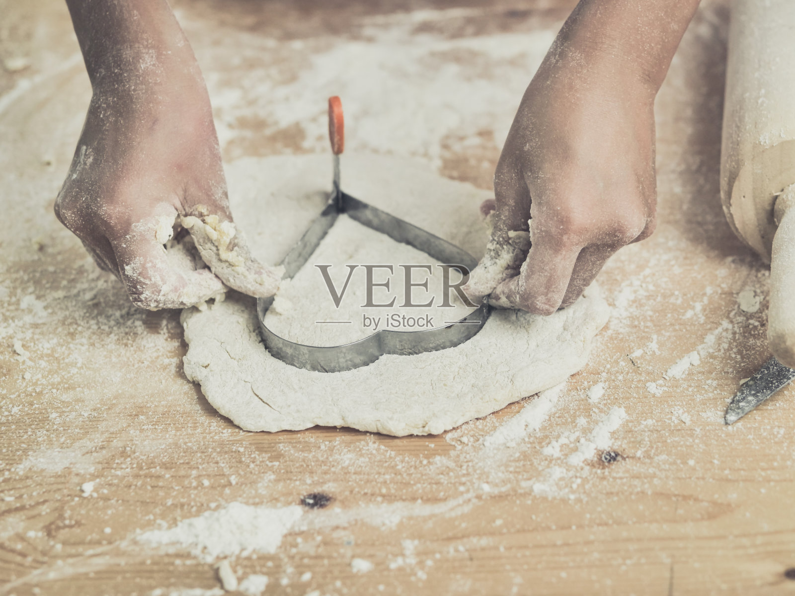 女孩双手捏成心形面团放在桌上，生活理念。照片摄影图片