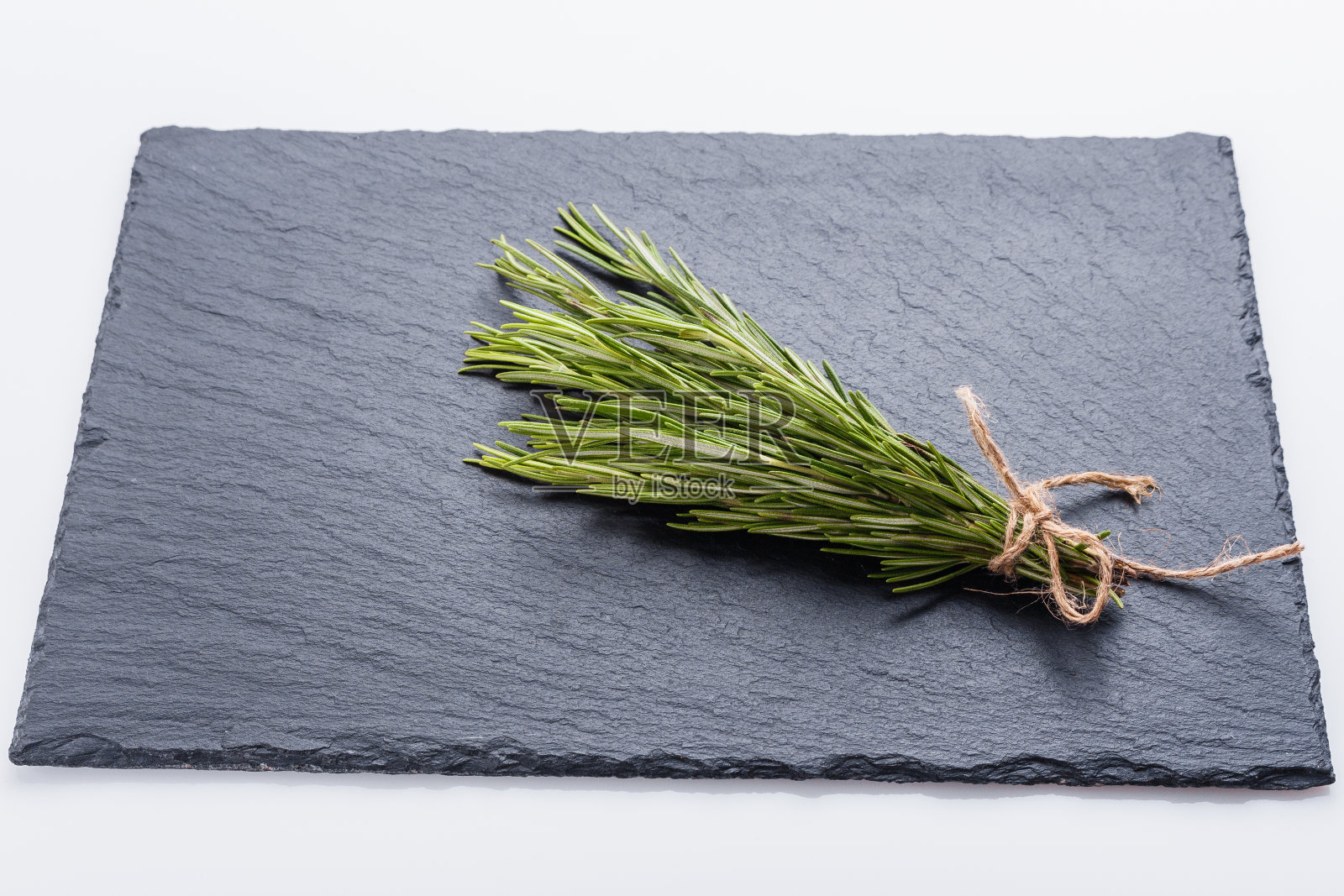 迷迭香精油在黑色的石头背景照片摄影图片