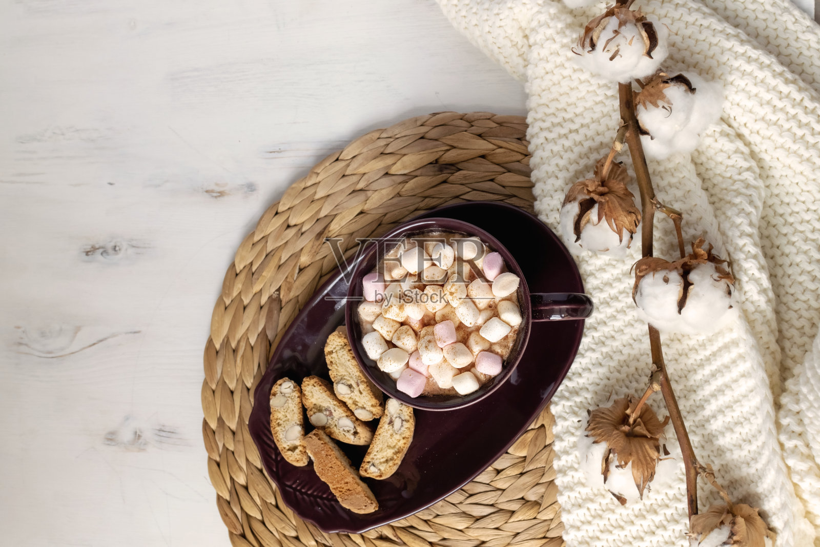 热巧克力与棉花糖，饼干，干棉花枝在草垫，针织格子，hygge风格照片摄影图片