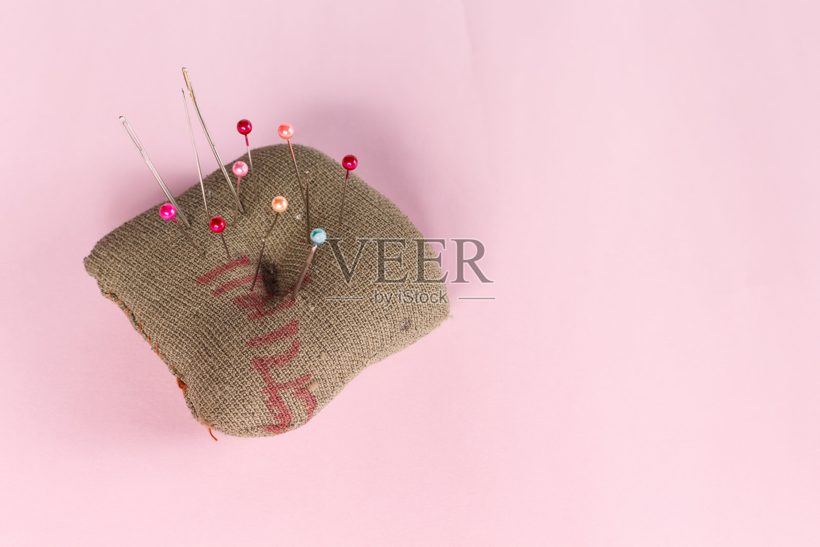 针脚在粉红色的背景上。照片摄影图片