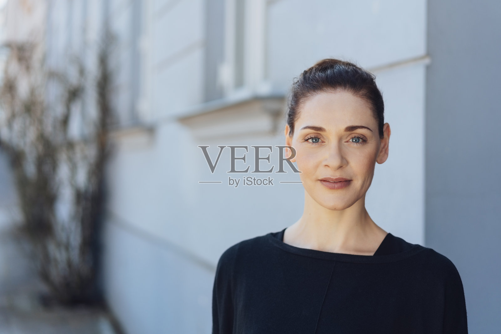 挽着一个发髻，优雅迷人的女人照片摄影图片