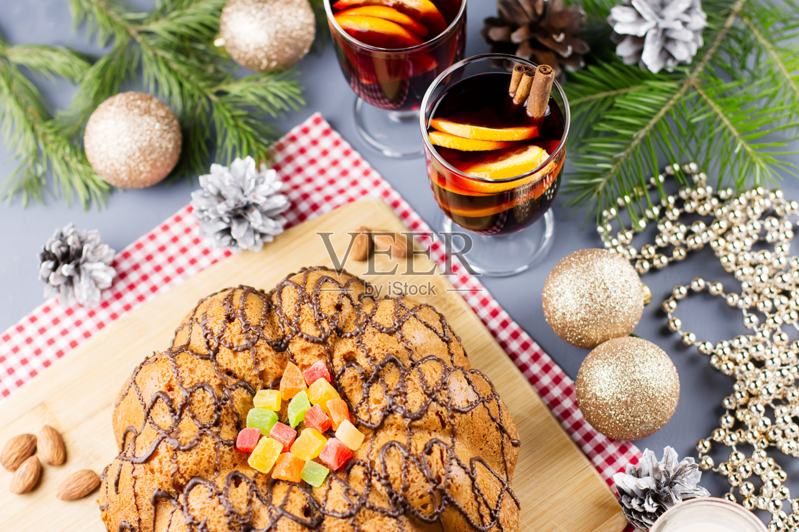 圣诞蛋糕，两杯热红酒和橙子片。圣诞背景的食物和装饰品。照片摄影图片