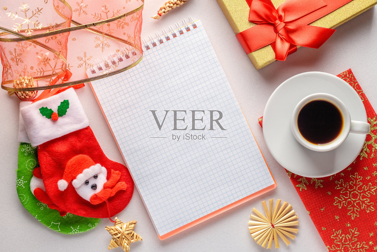 明亮的平面躺着一杯咖啡，笔记本，礼物包装和圣诞装饰照片摄影图片