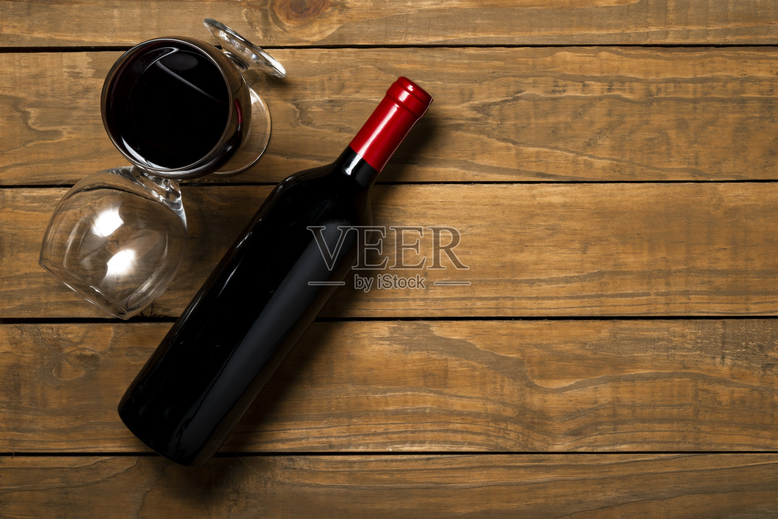 木制背景上的酒瓶和玻璃杯。顶部视图与复制空间照片摄影图片