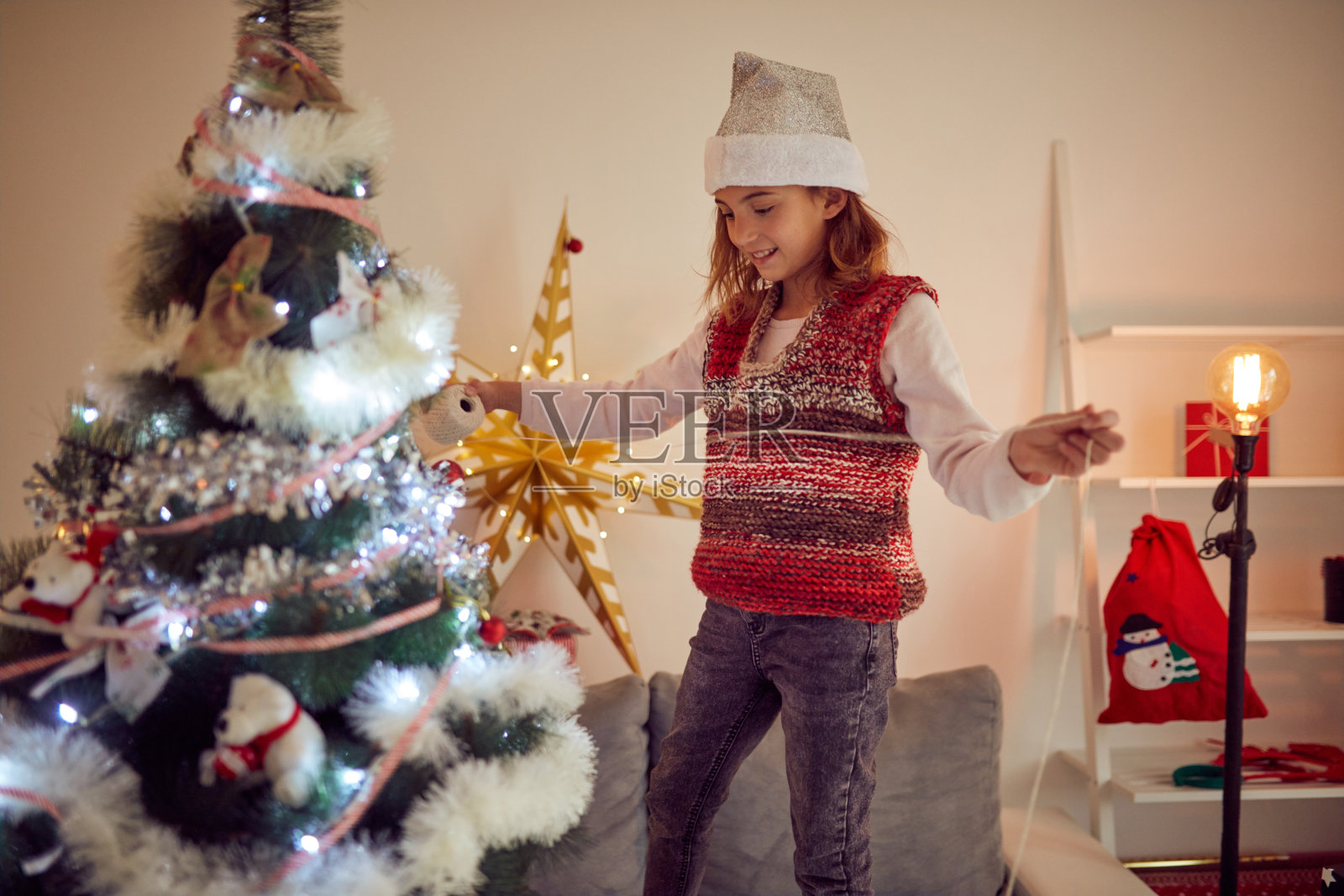 小女孩正在为圣诞节/新年前夜准备闪亮的装饰。照片摄影图片