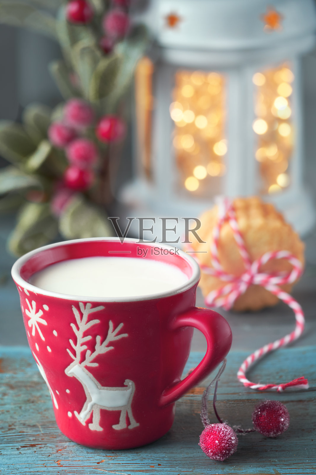 特写红杯牛奶与圣诞鹿设计，饼干，圣诞灯在灯笼和装饰照片摄影图片