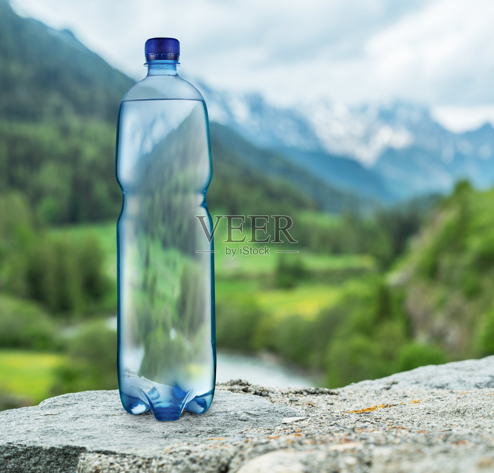 石头上有一瓶水。照片摄影图片