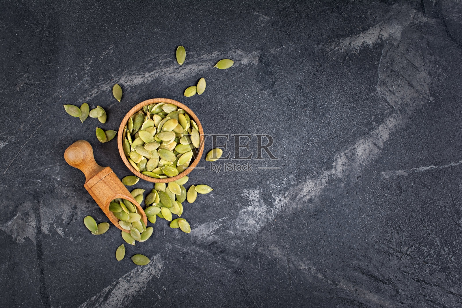 俯视图生绿色南瓜籽在木碗照片摄影图片
