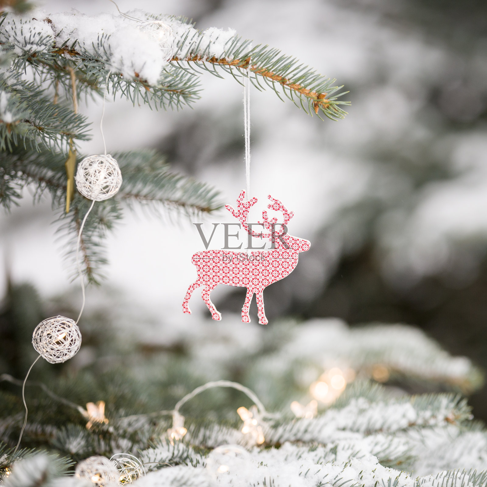 在冬天的森林里，白雪覆盖的常青树与漂亮的圣诞装饰的特写。冬天，圣诞节庆祝，节日季节。照片摄影图片