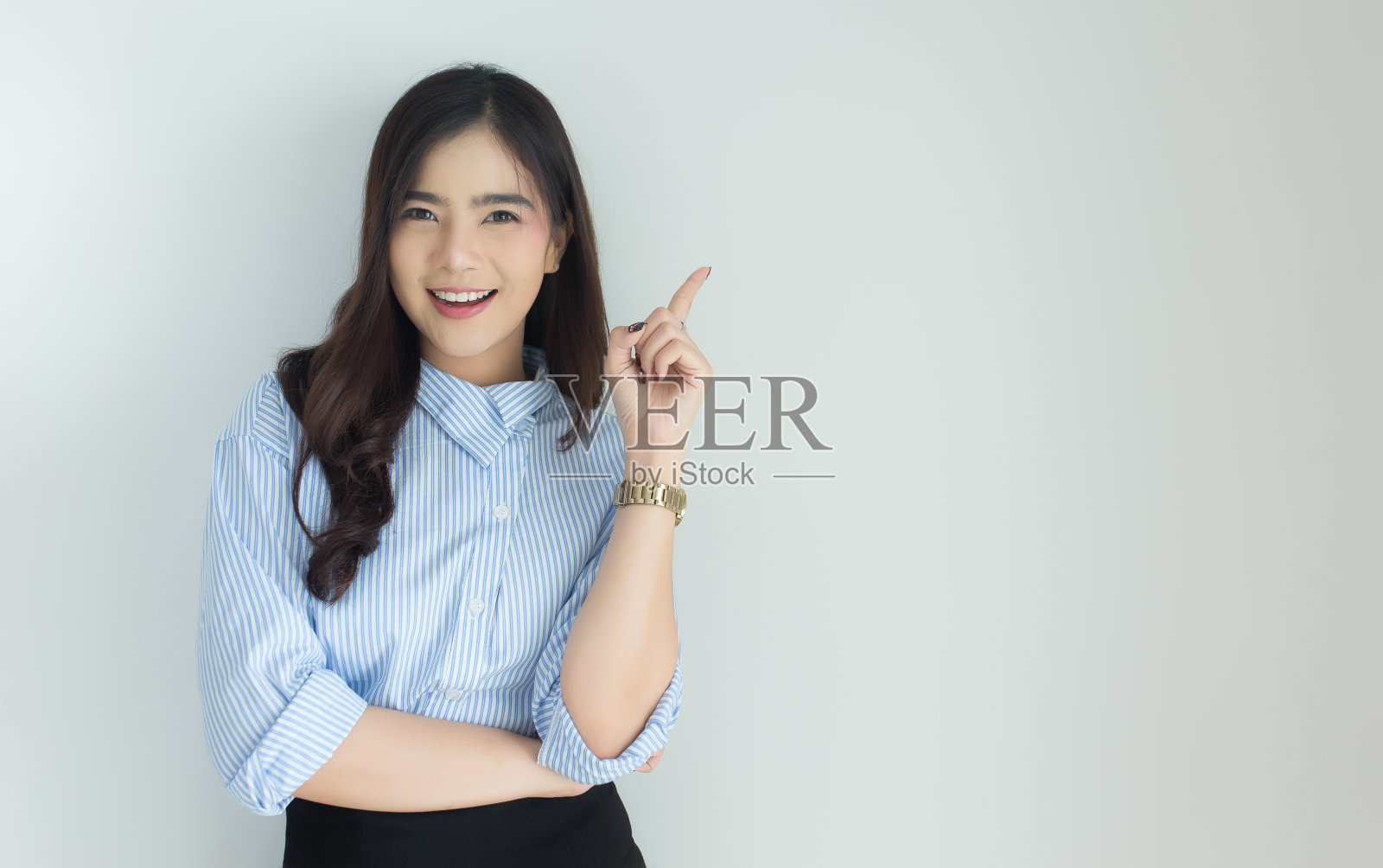 一幅年轻亚洲女商人的肖像，在白色的背景下向上指照片摄影图片