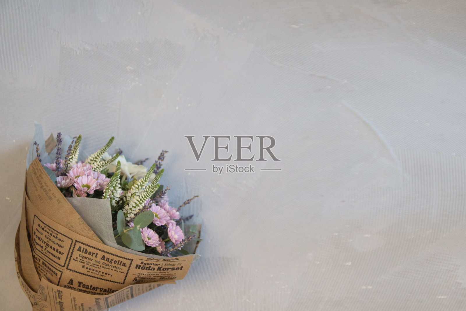 新鲜的绣球花，口水仙，玫瑰，桉树，薰衣草，淡粉色和奶油色的花朵在灰色的墙壁背景上盛开照片摄影图片