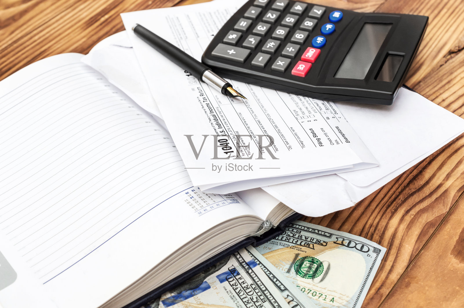 空白记事本，填写税单，现金和办公室计算器。照片摄影图片