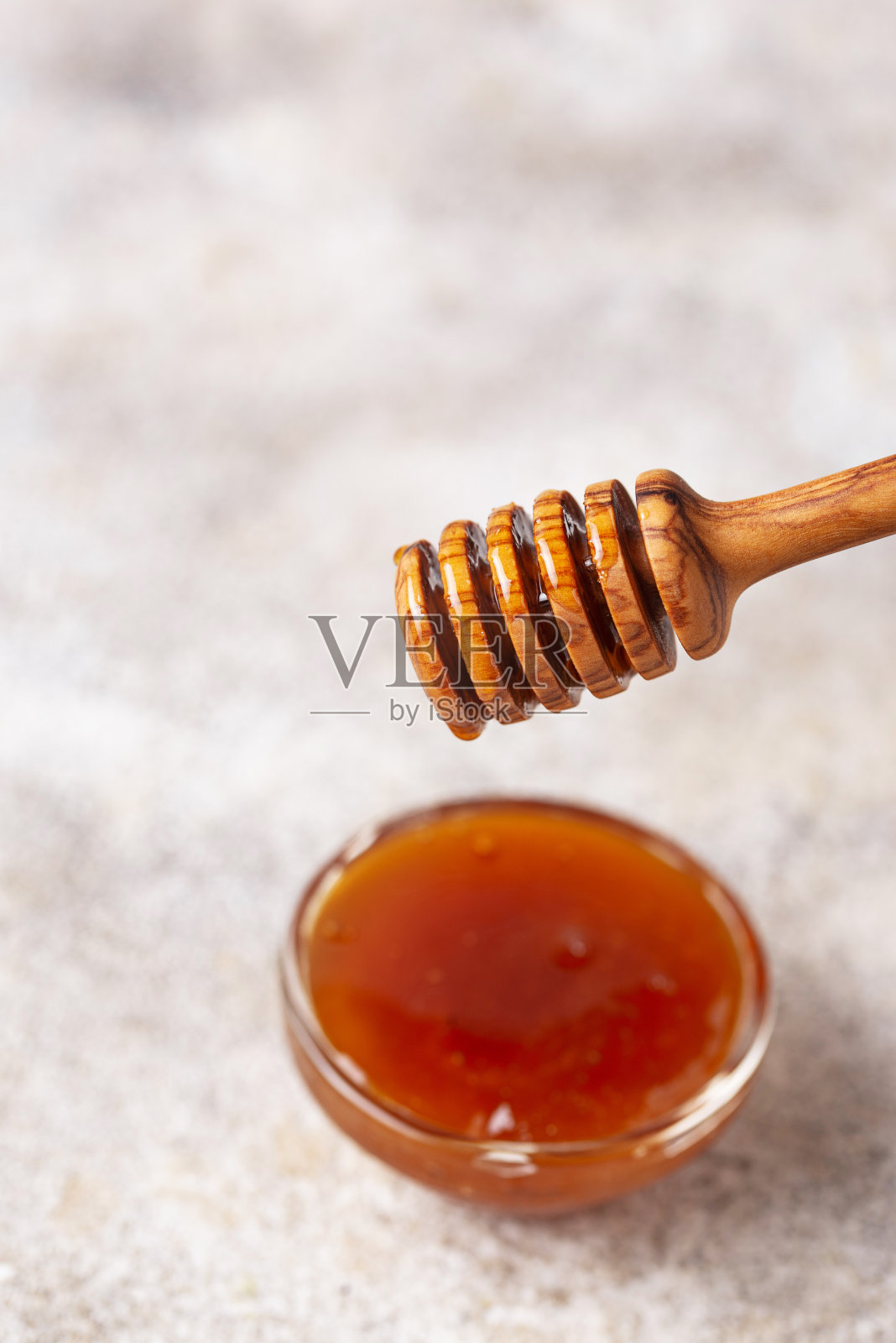 蜂蜜从木勺上滴下来照片摄影图片