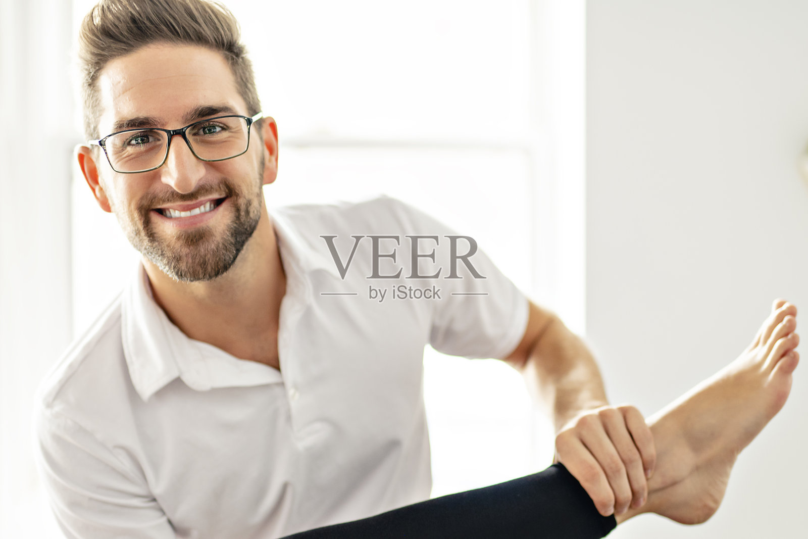 一个现代康复理疗男人在工作与女性客户工作腿照片摄影图片