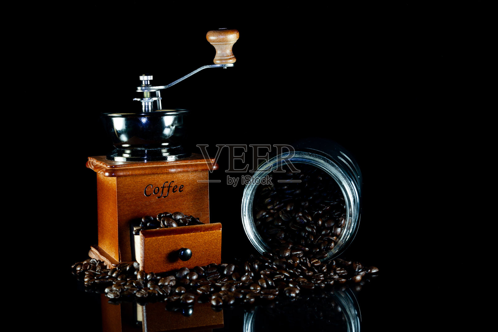 黑色背景上的咖啡豆和老式的木制咖啡研磨机。照片摄影图片