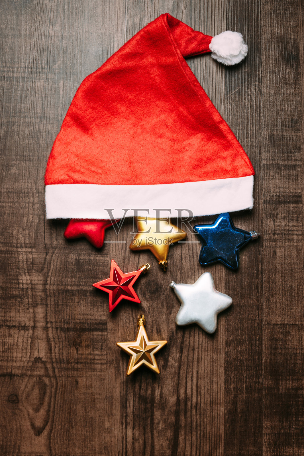 木制背景上有金属星星的圣诞老人帽。平铺圣诞和快乐新年横幅照片摄影图片
