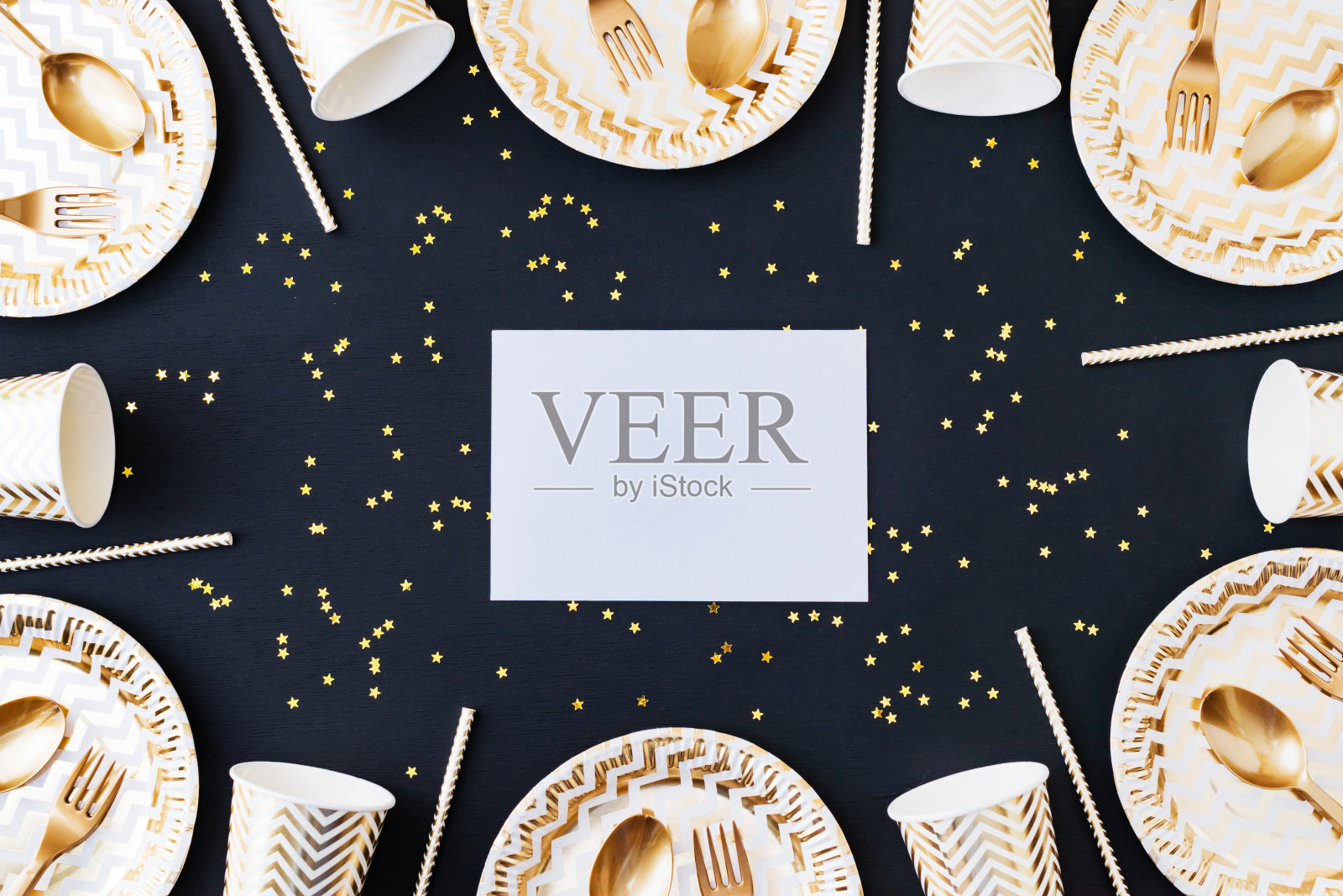聚会装饰背景。深色木质背景上的金色一次性餐具照片摄影图片