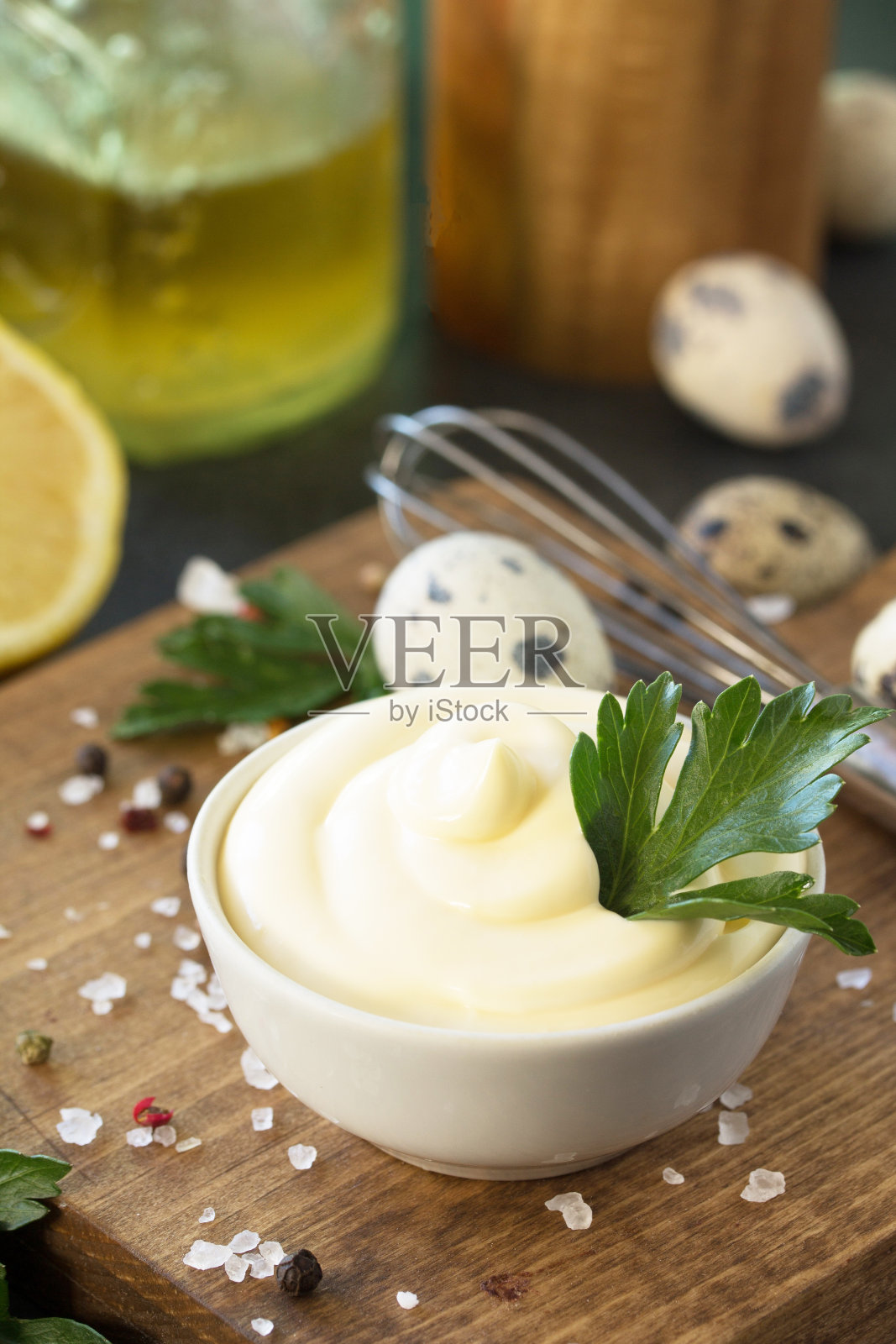 美乃滋酱特写。自制的蛋黄酱放在白色的碗里，背景是黑色的石头或混凝土。照片摄影图片