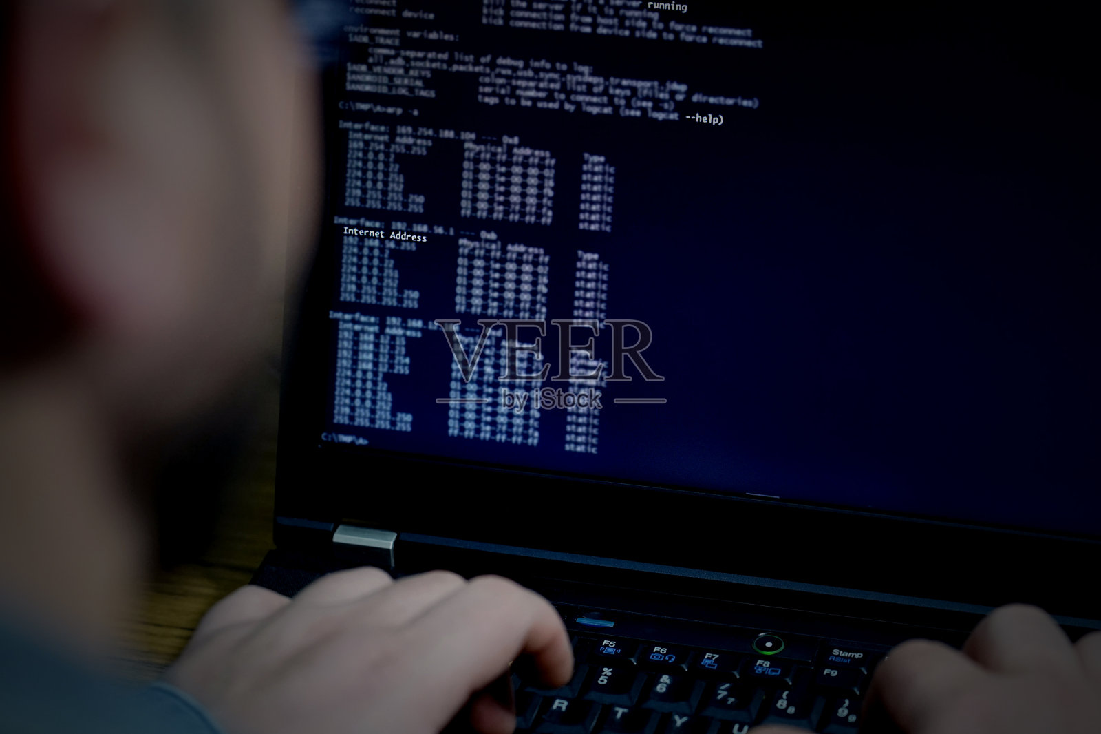 黑客使用笔记本电脑，电脑屏幕上有很多数字照片摄影图片