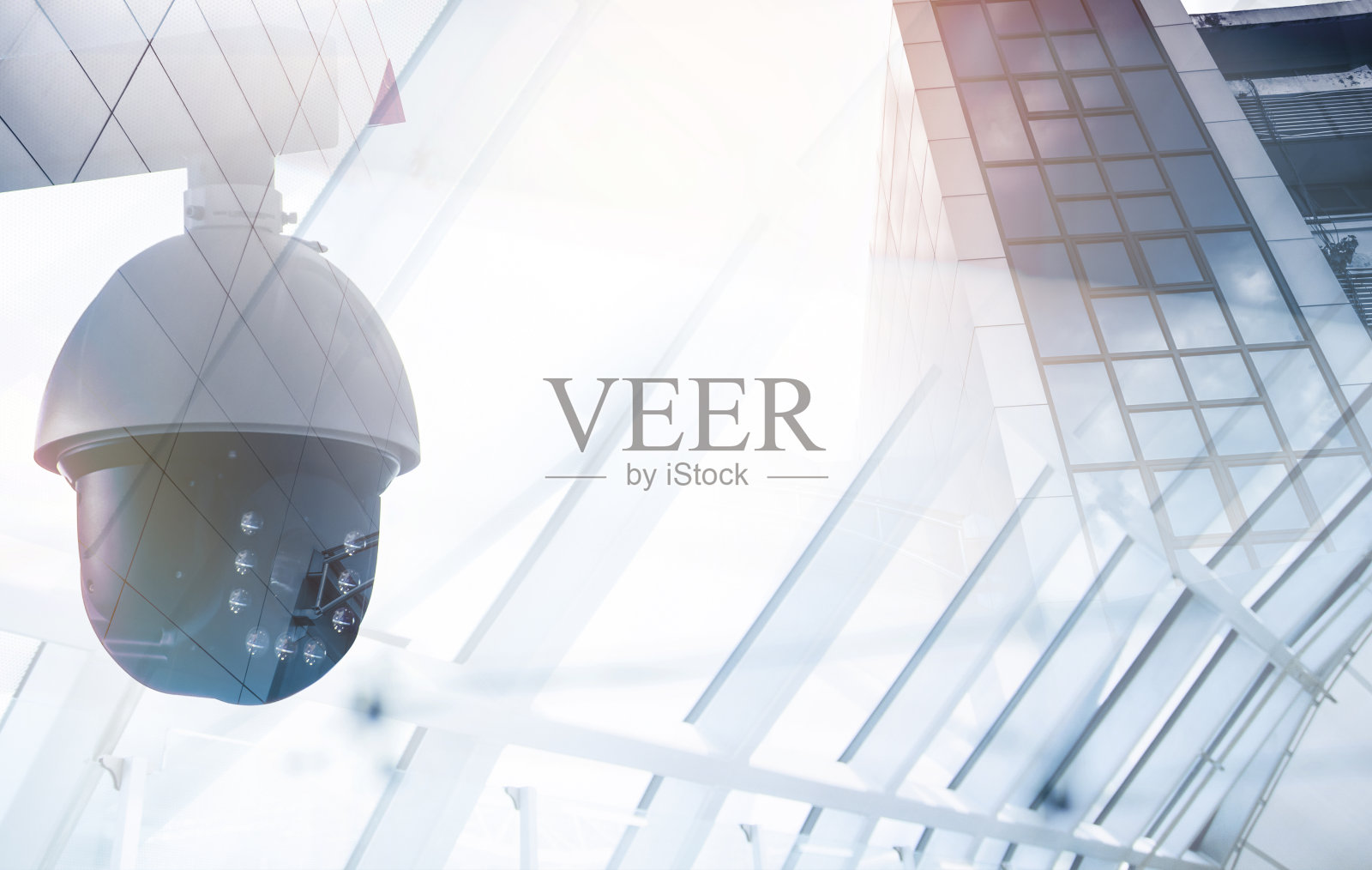 墙上的现代闭路电视摄像头以一个有雾的城市为背景，双曝光模拟照片摄影图片