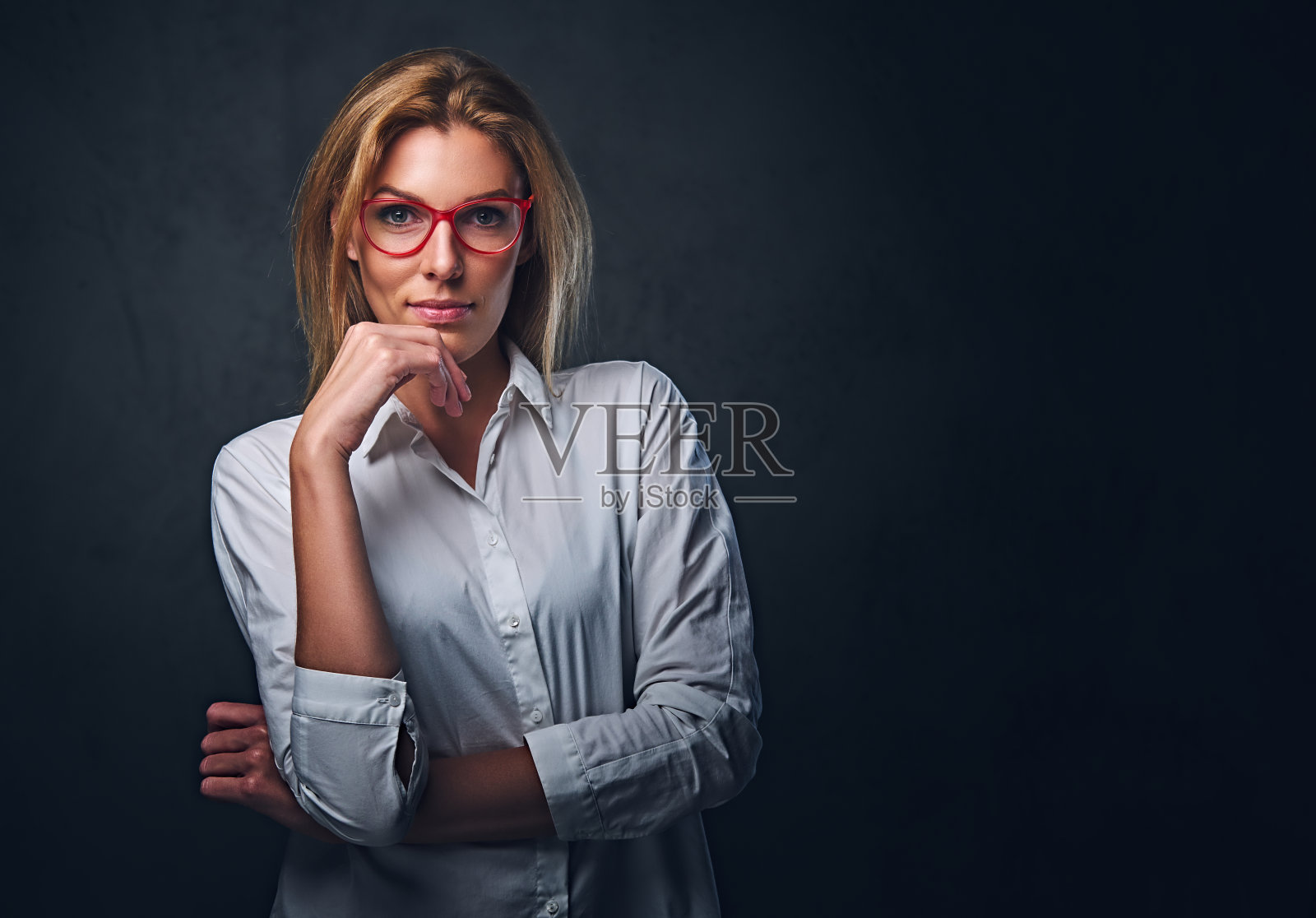 金发女人，穿着白衬衫，戴着红眼镜。照片摄影图片