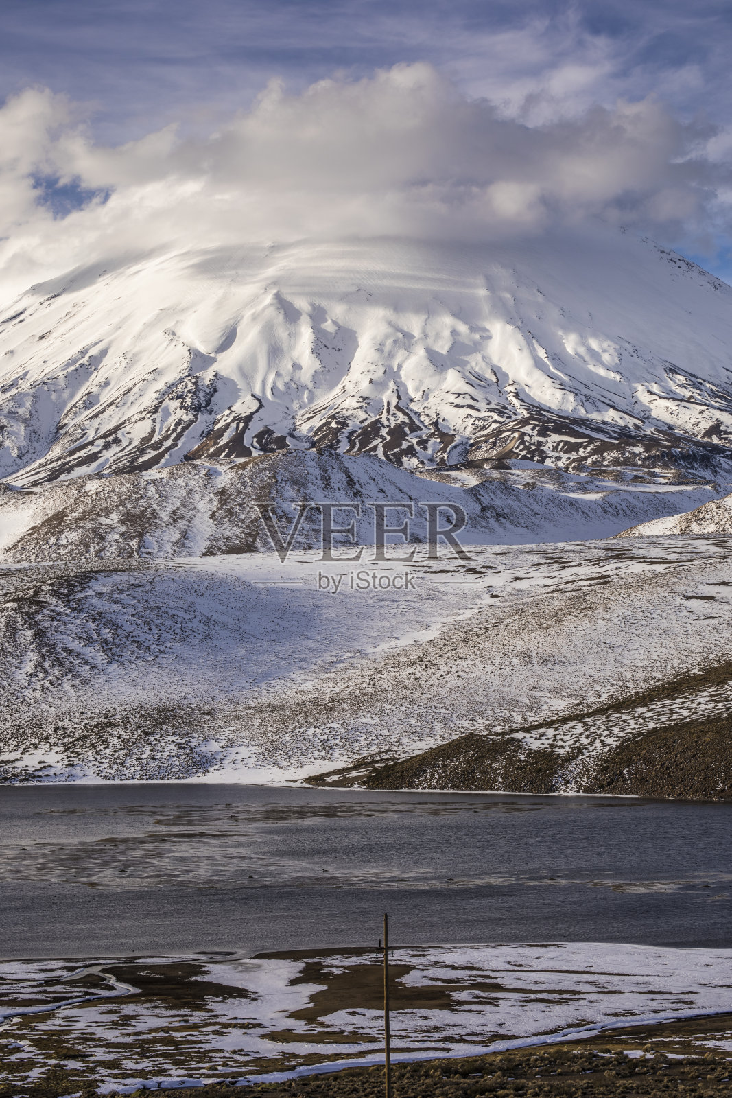 帕利纳科塔火山在Chungara湖的地平线上，在劳卡国家公园内壮观的云雾景观。安第斯山脉内智利“高原”的全景照片摄影图片