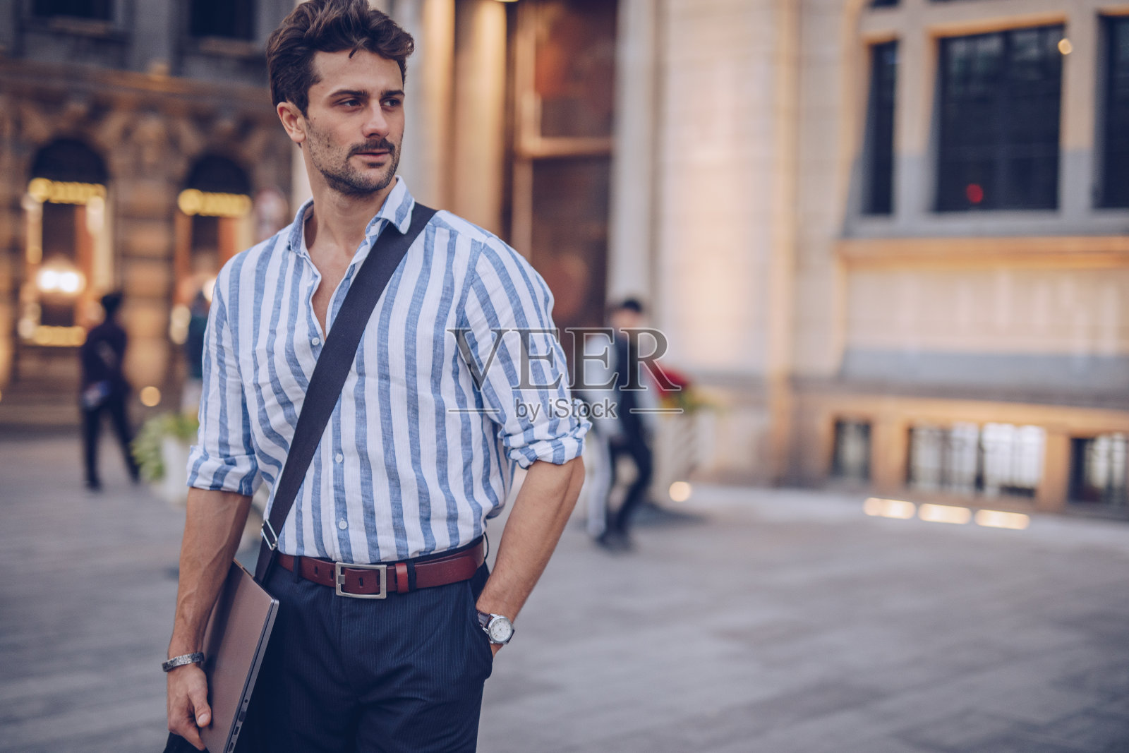 带着笔记本电脑站在城市街道上的时髦商人照片摄影图片