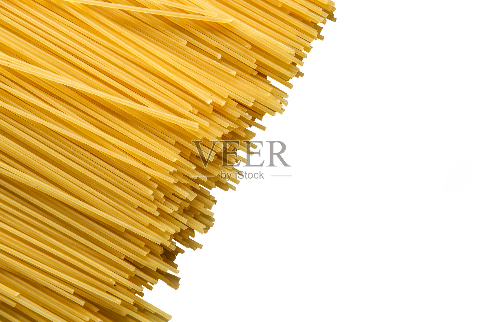 近,宏。俯视图，平放。生的黄色长面条孤立在白色背景上。副本的空间。照片摄影图片