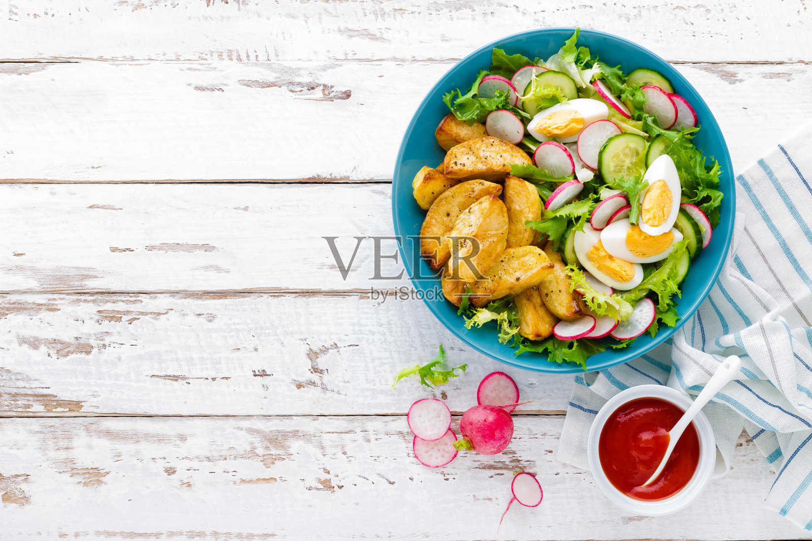 美味的烤土豆，煮鸡蛋和新鲜蔬菜沙拉的生菜，黄瓜和萝卜。夏季排毒食谱照片摄影图片