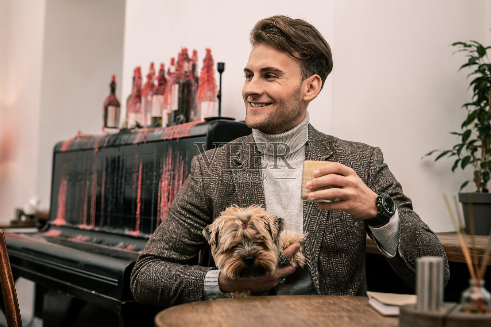 抱着狗喝咖啡的男人照片摄影图片