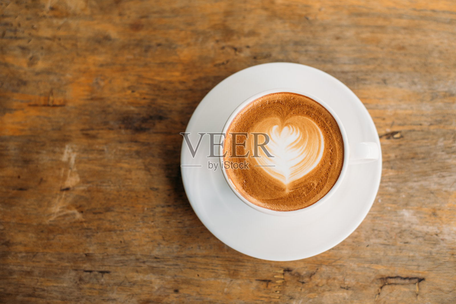 木桌上放着一杯卡布奇诺和拉花艺术照片摄影图片