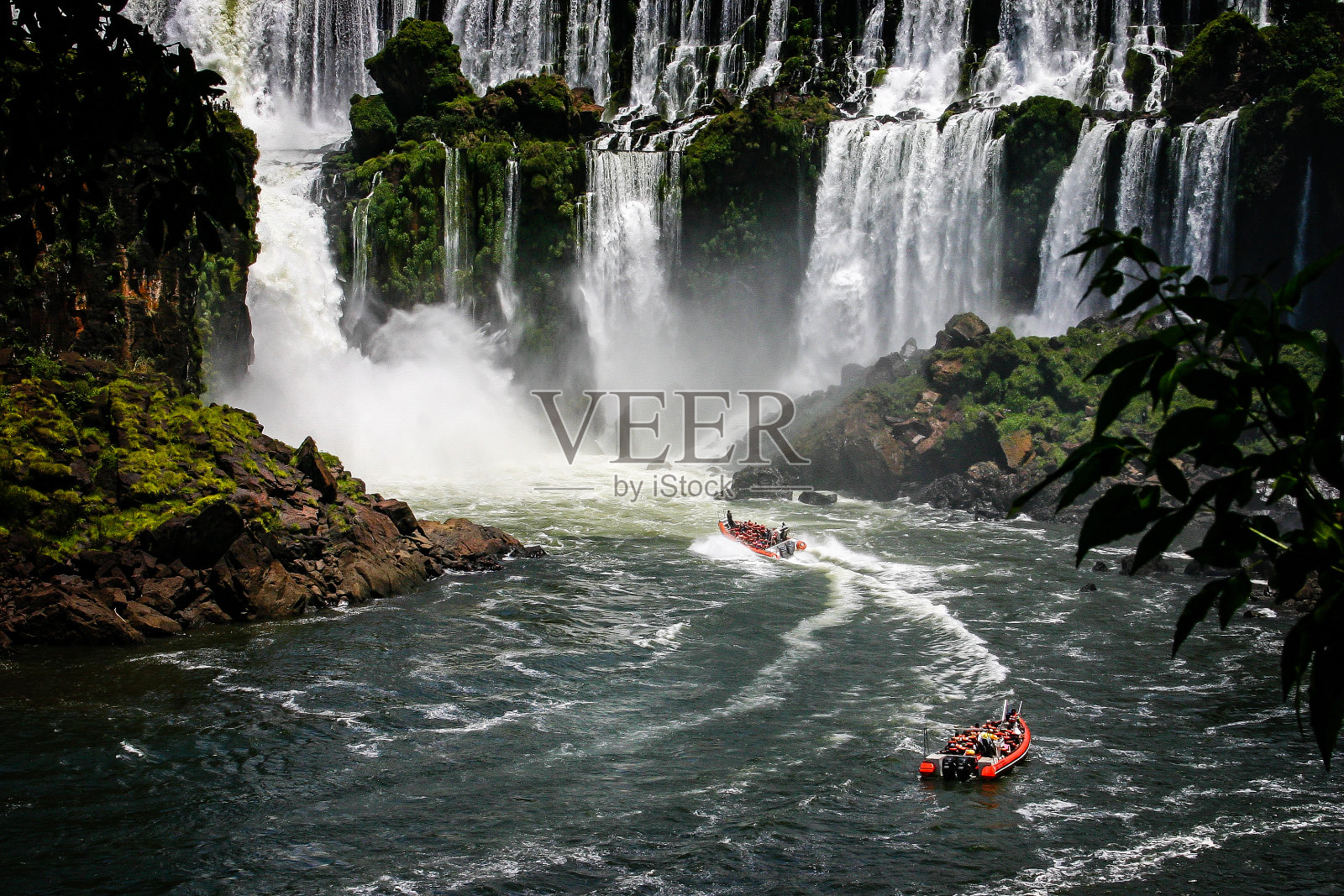 一艘快艇在巴西的伊瓜苏瀑布下滑行照片摄影图片