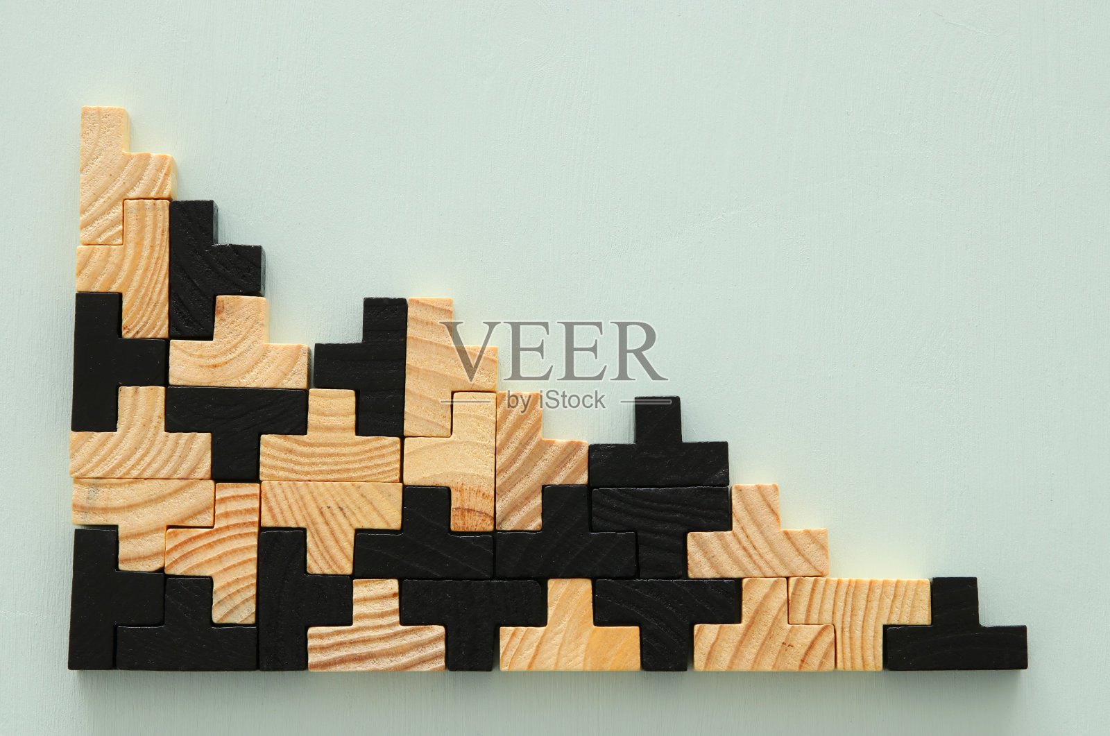 一个木制的方形七巧板拼图，在薄荷背景上。照片摄影图片