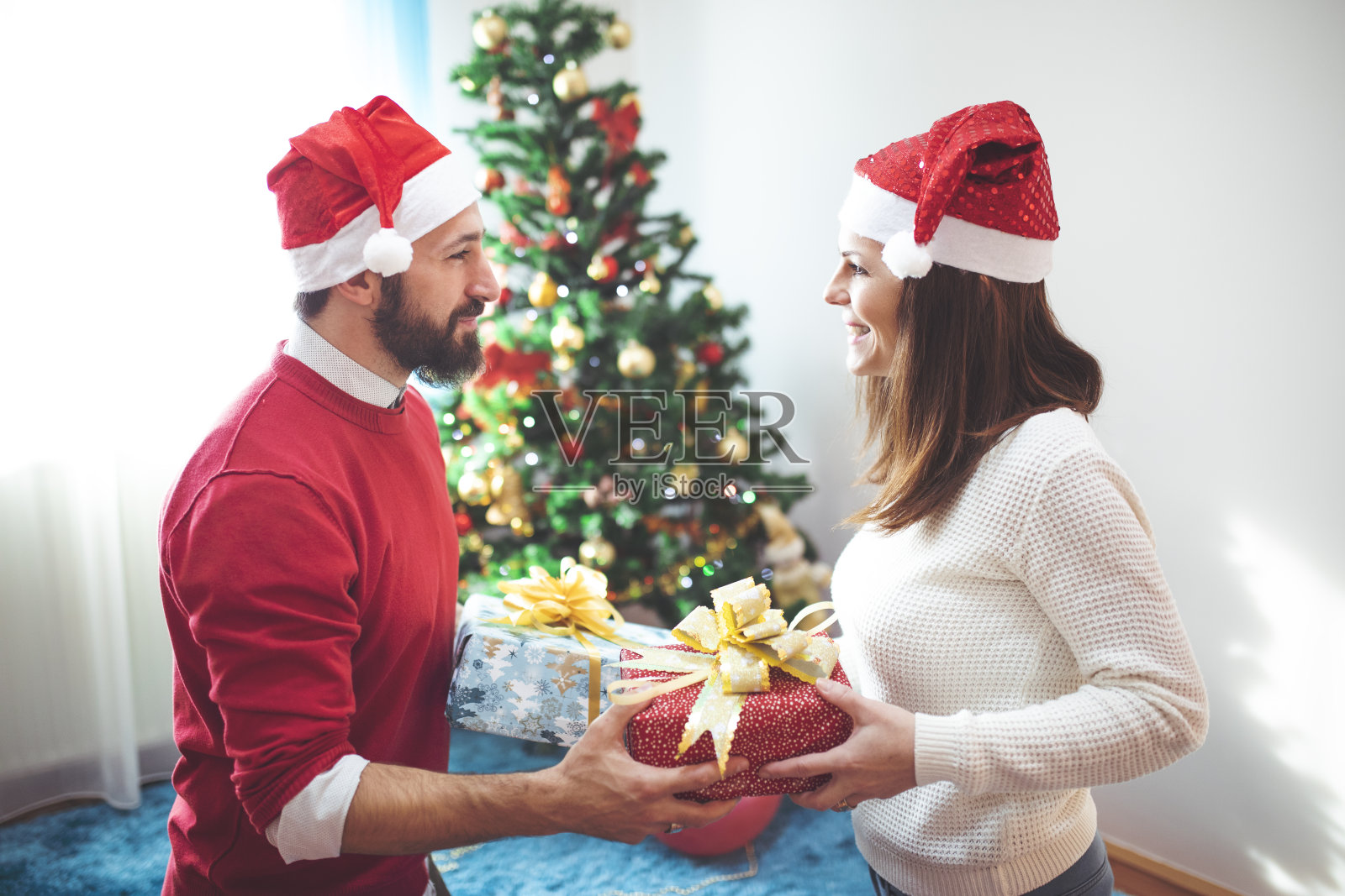 快乐微笑的夫妇交换圣诞礼物照片摄影图片