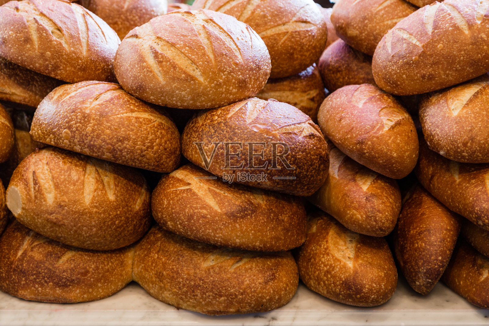 面包堆在面包房里准备出售和食用的新鲜酸面包照片摄影图片