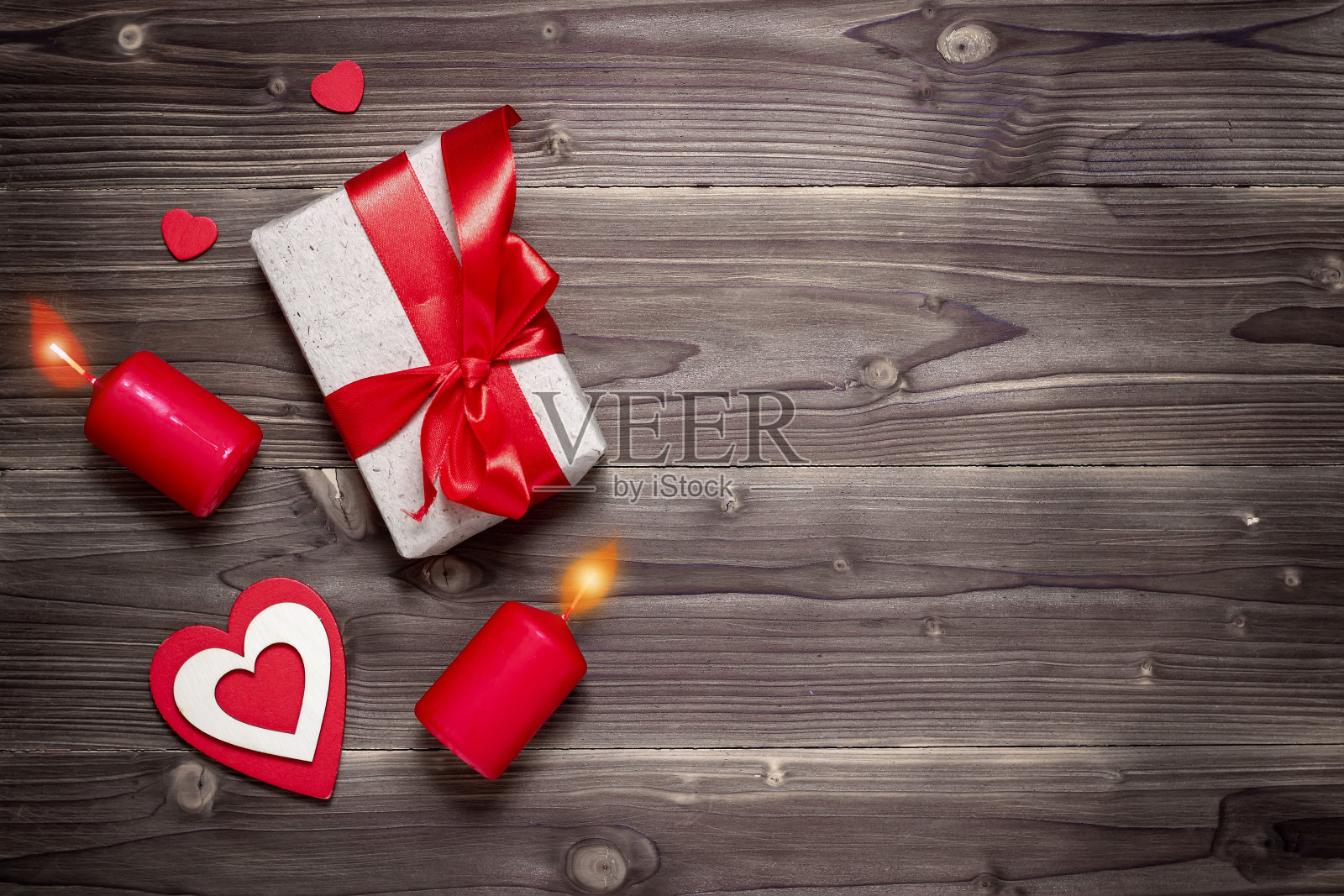 礼盒和装饰心与红色蜡烛在乡村木制背景。情人节。照片摄影图片