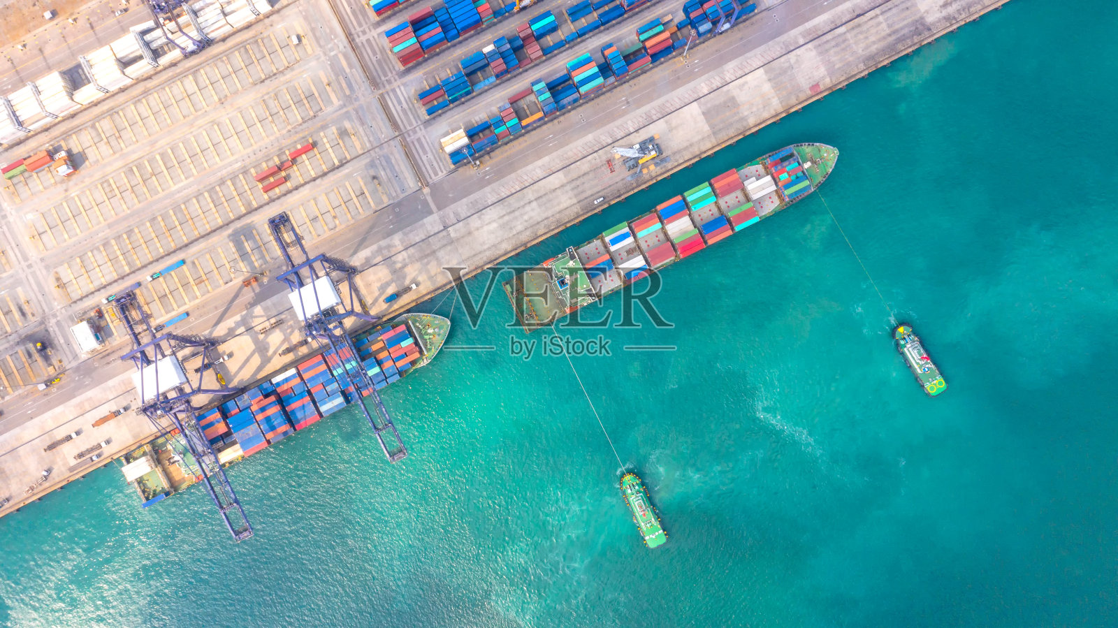 集装箱船在进出口业务和物流。用起重机将货物运到港口。国际水路运输。鸟瞰图和俯视图。照片摄影图片